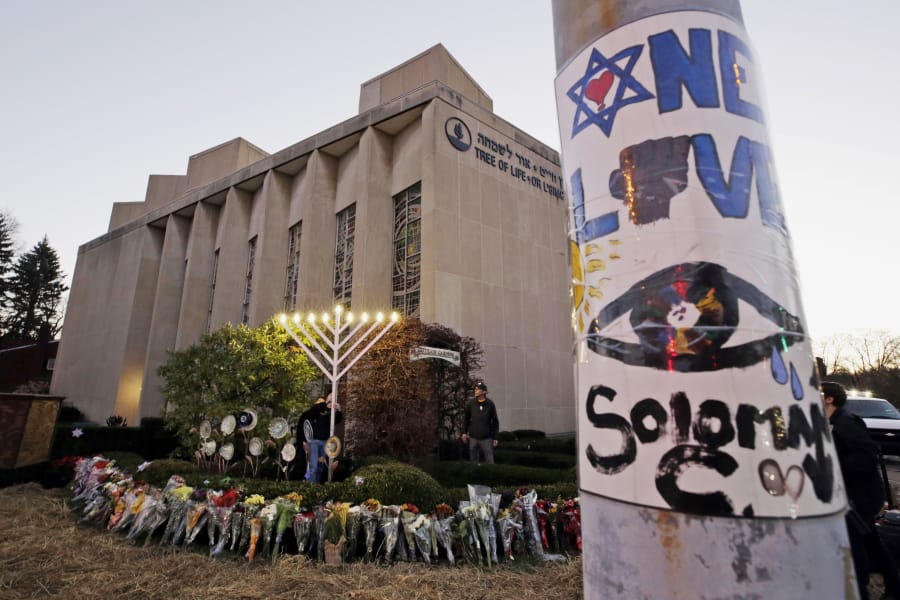 FILE - This Dec. 2, 2018, file photo shows a menorah at a memorial outside the Tree of Life Synagogue, where Robert Bowers killed worshippers in an Oct. 27 shooting, as people prepare for a celebration service at sundown on the first night of Hanukkah in the Squirrel Hill neighborhood of Pittsburgh. Bowers, charged with killing 11 worshippers at the Pittsburgh synagogue last year, has a court hearing Monday, Aug. 12, 2019. Prosecutors have not made a final decision on whether to seek the death penalty. Bowers is not expected to be in court. (AP Photo/Gene J.