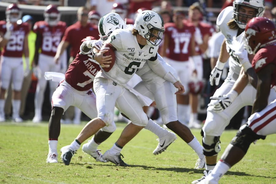 Portland State quarterback Davis Alexander tries to get away from Arkansas defender Joe Foucha as he scrambles out of the pocket in the first half of an NCAA college football game, Saturday, Aug. 31, 2019 in Fayetteville, Ark.