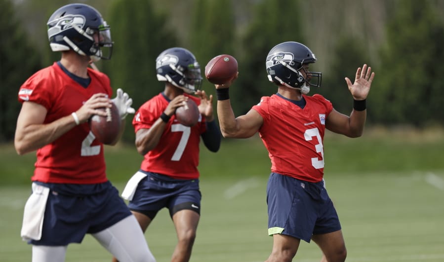 Seattle Seahawks starting quarterback Russell Wilson (3) leads Paxton Lynch (2) and Geno Smith (7) in a quarterbacks drill at an NFL football training camp Thursday, Aug. 1, 2019, in Renton, Wash.