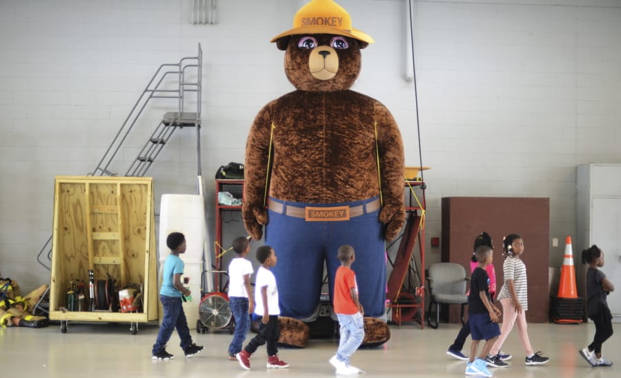 A giant Smokey Bear figure greets children at a fire department open house in Kinston, N.C., in 2017. The icon of the longest-running public service campaign in the U.S. was born on Aug. 9, 1944. janet s.