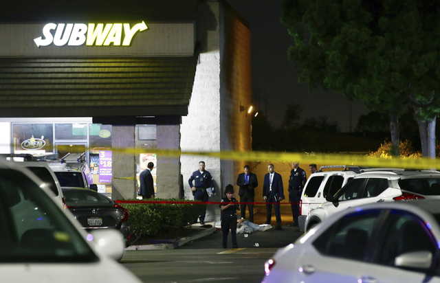 GRAPHIC CONTENT - Police work the scene of a stabbing in Santa Ana, Calif., Wednesday, Aug. 7, 2019. A man killed multiple people and wounded others in a string of robberies and stabbings in California's Orange County before he was arrested, police said Wednesday.