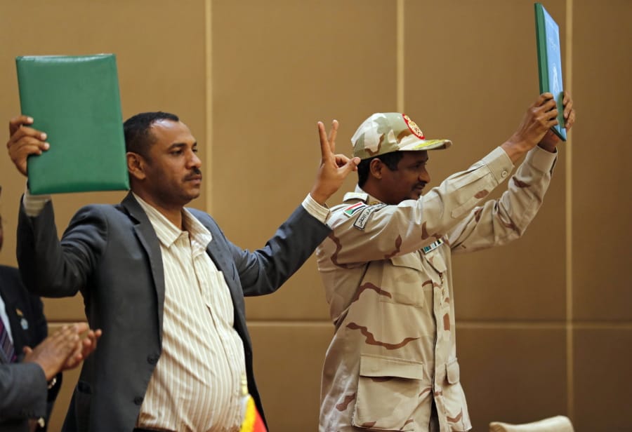 Gen. Mohammed Hamdan Dagalo, the deputy head of the military council, right, and Protest leader Ahmad Rabie hold up a signed agreement at a ceremony attended by African Union and Ethiopian mediators in the capital Khartoum, Sudan, Sunday, August 4, 2019. Sudan’s pro-democracy movement has signed a power-sharing agreement with the ruling military council aimed at paving the way for a transition to civilian rule following the overthrow of President Omar al-Bashir in April. Representatives of both sides signed a constitutional document on Sunday that would establish a joint military and civilian council to rule for a little over three years until elections can be held.