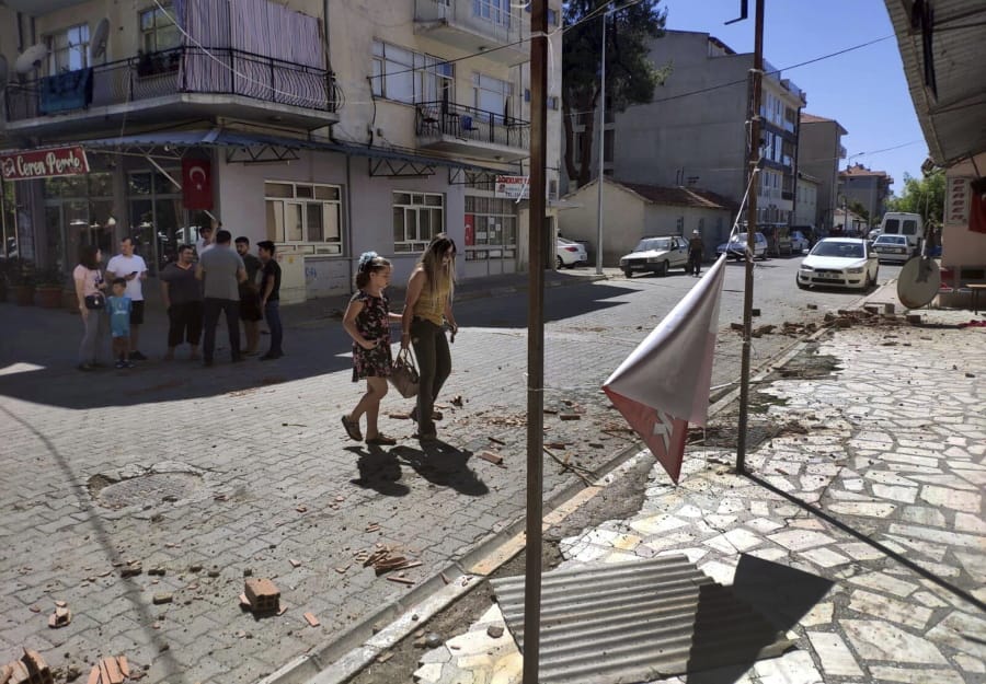 Minor damage, from an earthquake is seen on a street as residents stay out of buildings and on streets in Bozkurt, in Denizli province, west Turkey, Thursday, Aug. 8, 2019. The earthquake with an estimated magnitude of 6.0 hit western Turkey, damaging homes and causing some injuries, officials said. Bozkurt’s mayor, Birsen Celik, told media that the quake knocked down two houses in the town but residents escaped with slight injuries. Several other homes were damaged with cracked walls.