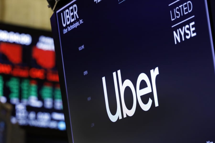 FILE - In this Aug. 9, 2019, file photo, the logo for Uber appears above a trading post on the floor of the New York Stock Exchange. Texas Gov. Greg Abbott has announced that Uber will receive a $24 million state incentive package and open a new administrative hub in Dallas, bringing with it about 3,000 jobs. Abbott said in a statement Tuesday, Aug. 20, 2019, that the Dallas offices will house various corporate functions.