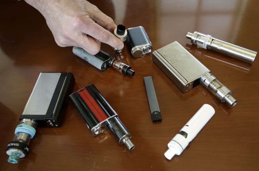 In this Tuesday, April 10, 2018 photo, Marshfield High School Principal Robert Keuther displays vaping devices that were confiscated from students in such places as restrooms or hallways at the school in Marshfield, Mass. Illinois health officials are reporting what could be United States’ first death tied to vaping. In a Friday, Aug. 23, 2019, news release, the Illinois Department of Public Health says a person who recently vaped died after being hospitalized with “severe respiratory illness.” The agency didn’t give any other information about the patient, including a name or where the person lived.