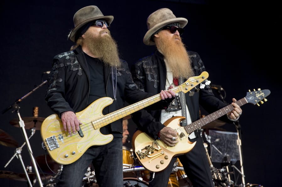 FILE - In this June 24, 2016, file photo, Dusty Hill, left, and Billy Gibbons from the rock band ZZ Top perform at the Glastonbury music festival at Worthy Farm, in Somerset, England. Joe Walsh will be joined by ZZ Top, Brad Paisley, Sheryl Crow, and Jason Isbell and The 400 Unit at his VetsAid music festival to benefit veterans. The award-winning musician announced Monday, Aug. 12, 2019, file photo, that tickets for the Nov. 10 concert at the Toyota Center in Houston will go on sale Friday.