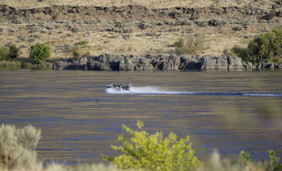 In this Wednesday, Aug. 14, 2019 photo, a boat motors along Columbia River near the Hanford Reach National Monument near Richland.