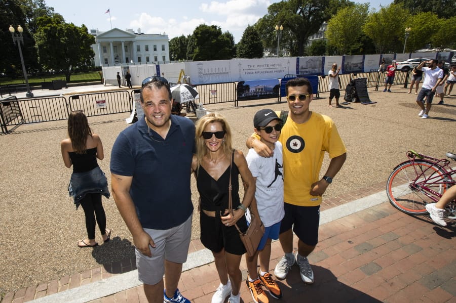 Parisian Paul and Anne-Paula Baptista, from left, together with their sons Louis and Clement Baptista, pose Thursday in front of the White House in Washington.