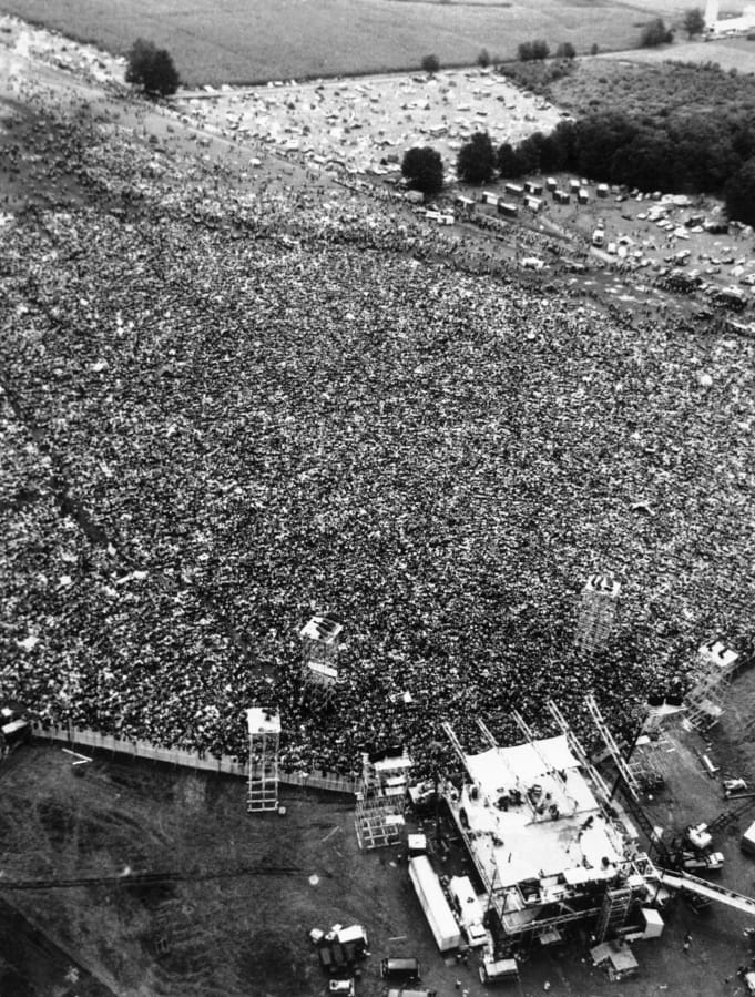 Thousands of rock music fans are packed around the stage at the Woodstock Festival. For the first time, an audio recording is available of nearly everything heard onstage at Woodstock 50 years ago — from transcendent music to announcements about lost people and bad acid.