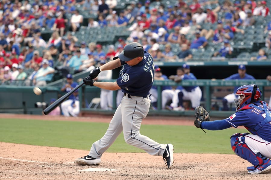 Seattle Mariners' Kyle Seager, left, connects for a three-run home run on a pitch from Texas Rangers reliever Taylor Guerrieri as catcher Jose Trevino, right, watches in the eighth inning of a baseball game in Arlington, Texas, Sunday, Sept. 1, 2019.