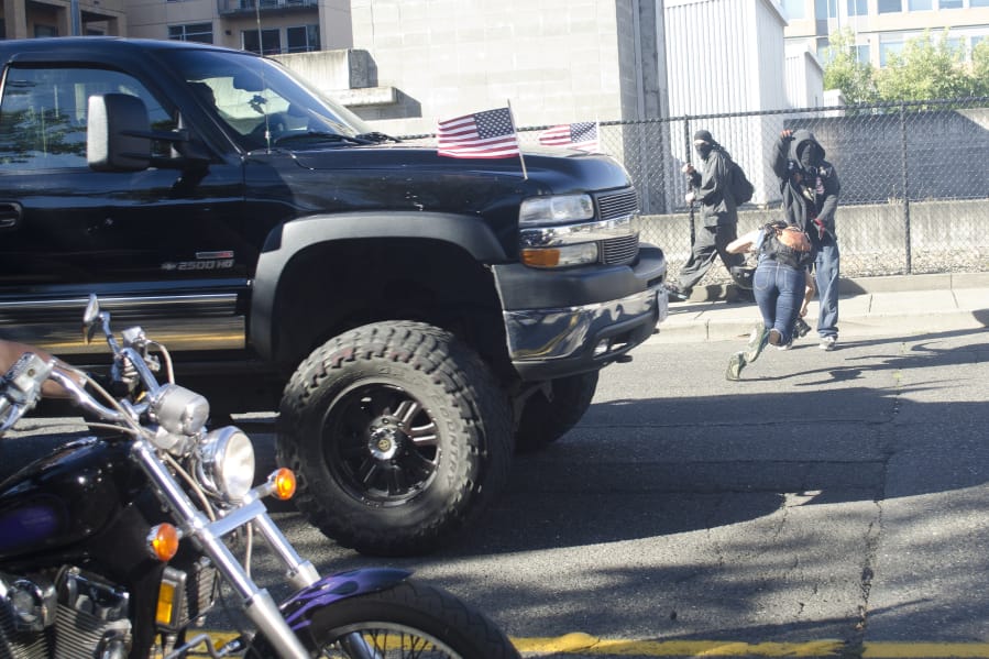 A photographer dives out of the way of a truck driven by William Donald &quot;Billy&quot; Wilson after a rally held by Joey Gibson&#039;s Patriot Prayer Group in Vancouver on Sept. 10, 2017. A judge on Tuesday dropped misdemeanor charges against Wilson in connection with the incident.