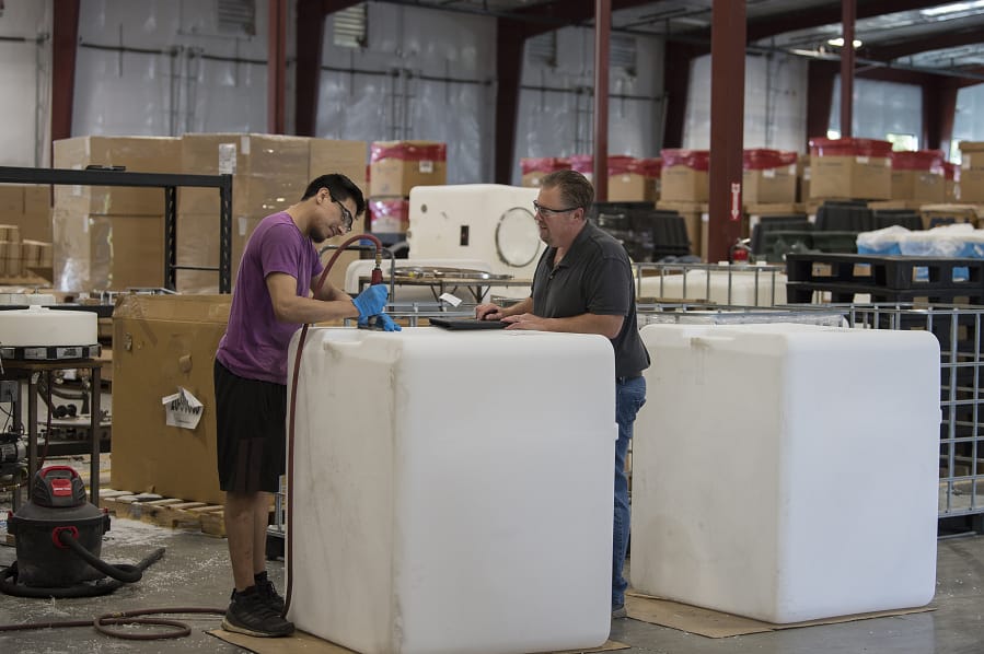 Erick Chavez, left, details a wine tank made of polyethylene while working with colleague Steve Downing at the newly expanded SmaK Plastics in Vancouver. A recent expansion nearly tripled the working floor space.