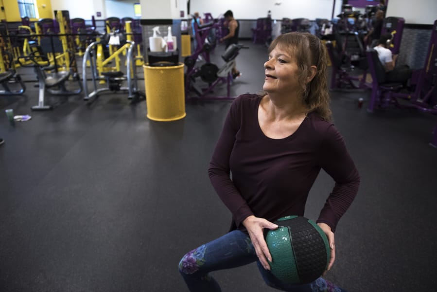 Kris Houston uses a medicine ball to work out at Planet Fitness in Hazel Dell. Houston has started working out four to five times a week since entering the Washington State University Clark County Extension Diabetes Prevention Program last year.