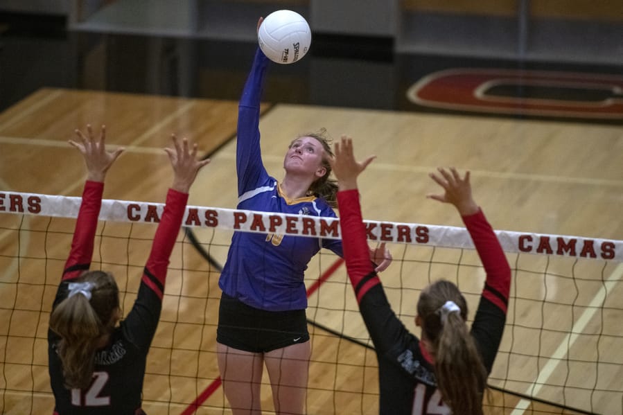 Columbia River's Ali Dreves (10) spikes the ball on Camas' Emmy Hansen (12) and Alliyah Barnes (14) at Camas High School on Tuesday evening, September 10, 2019.