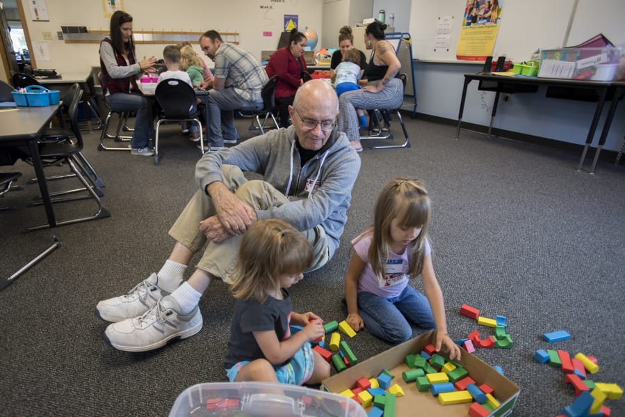 Ava West, 2, of Battle Ground, from left, joins her grandfather, Bill Jackson, and classmate Emma Betka, 3, as they play with blocks Wednesday afternoon at Daybreak Primary School. The activity was part of Let's Play and Learn Together, a free weekly drop-in program hosted by Battle Ground Public Schools for students age 5 or younger.