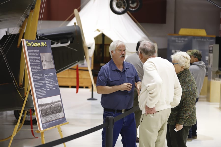 Mark Smith, left, of Century Aviation discusses the A 1918 Curtiss JN-4 "Jenny"  airplane that was dedicated as part of the exhibit at Pearson Air Museum on Saturday.
