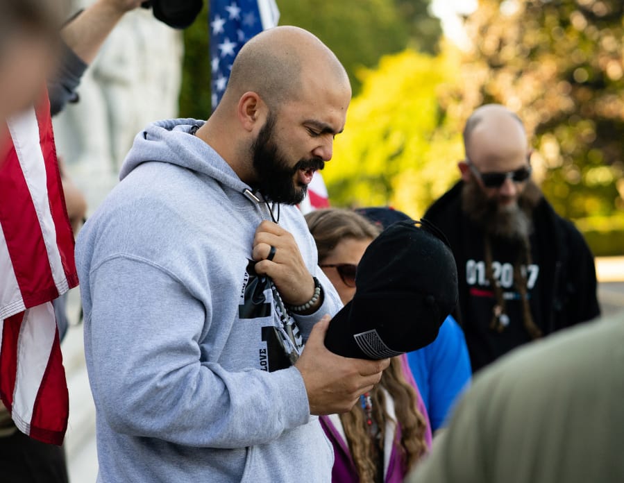 Joey Gibson, leads supporters in prayer on the steps of the Capitol Building in Salem, Ore. following the conclusion of a flag waving rally in October 2017. Gibson, the leader of Patriot Prayer, is extremely active on social media, where he has attracted a large following.