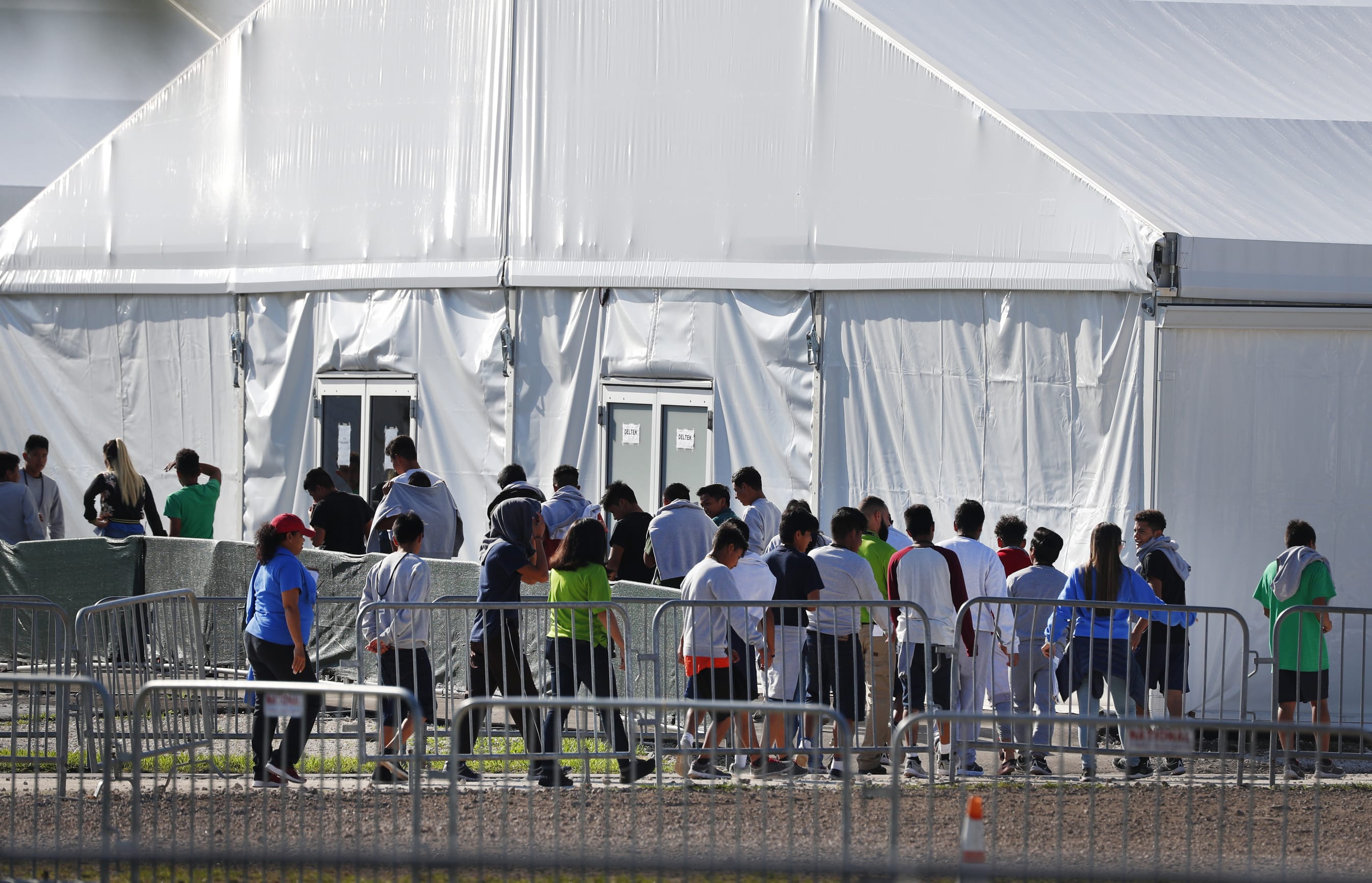 FILE- In this Feb. 19, 2019 file photo, children line up to enter a tent at the Homestead Temporary Shelter for Unaccompanied Children in Homestead, Fla.  Migrant children who were separated from their parents at the U.S.-Mexico border last year suffered post-traumatic stress and other serious mental health problems, according to an internal watchdog report obtained by The Associated Press Wednesday. The chaotic reunification process only added to their trauma.