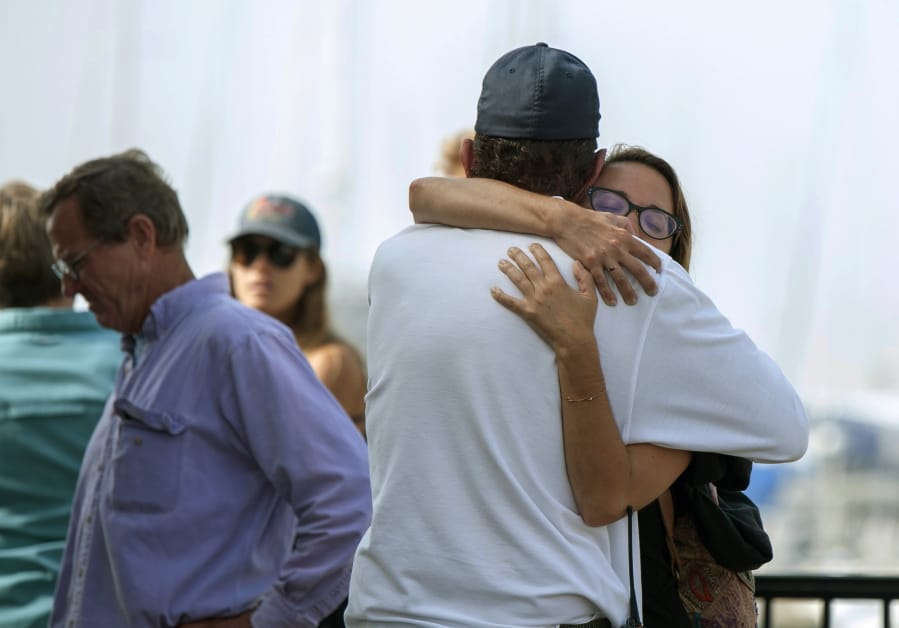 People hug each other as they await news outside of the Truth Aquatics office in Santa Barbara, Calif., on Monday, Sept. 2, 2019. Multiple people are feared dead after a dive boat caught fire before dawn Monday off the Southern California coast, according to the Coast Guard.