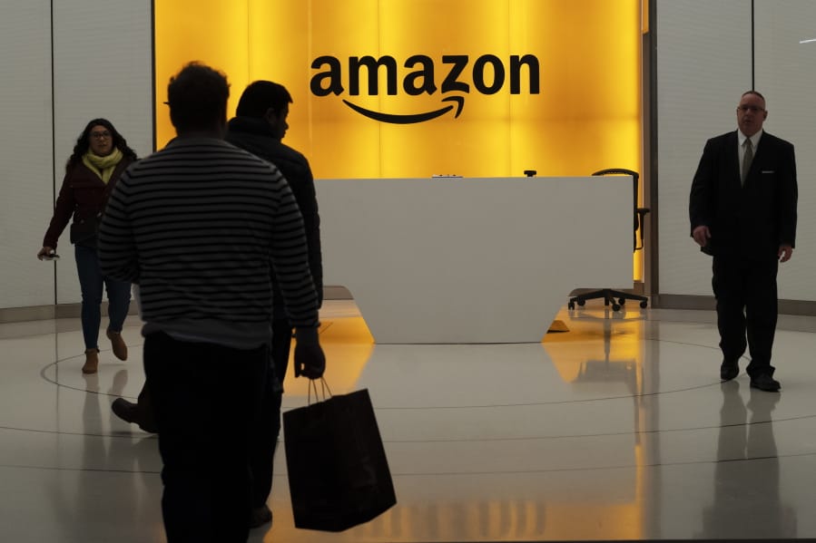 FILE - In this Feb. 14, 2019, file photo people walk into the lobby for Amazon offices in New York. The online shopping giant is holding job fairs across the country next week, aiming to hire more than 30,000 people by early next year, a 5% bump in its total workforce.
