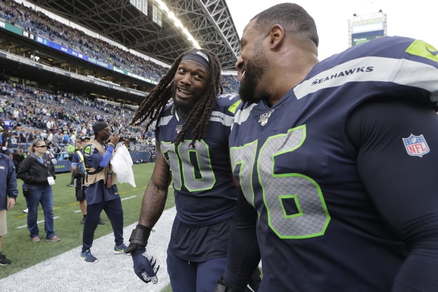 Seattle Seahawks defensive end Jadeveon Clowney, left, talks with teammate Duane Brown, right, after they defeated the Cincinnati Bengals in an NFL football game, Sunday, Sept. 8, 2019, in Seattle.