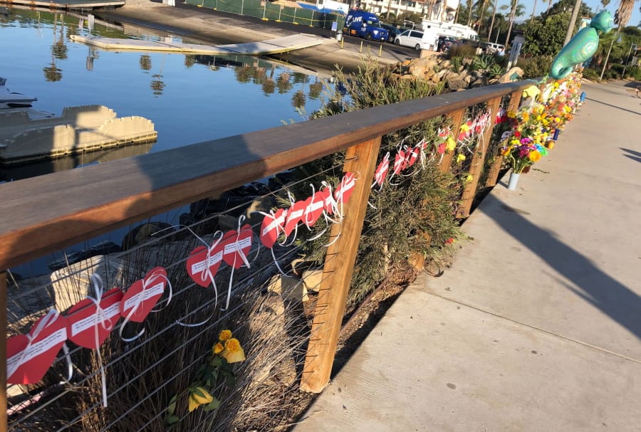 A row of hearts, each with the name of a victim, adorn a growing memorial to those who died aboard the dive boat Conception, seen early Friday morning, Sept. 6, 2019 at the harbor in Santa Barbara, Calif. The Sept.