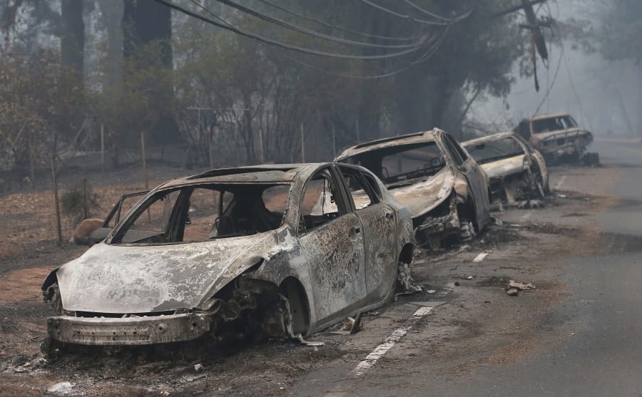FILE - This Nov. 9, 2018, file photo the burned out hulks of cars abandoned by their drivers sit along a road in Paradise, Calif. In July 2019, the legislature approved and Gov. Gavin Newsom signed a law that requires the state&#039;s three investor-owned utilities to spend a combined $5 billion on safety improvements and adopt new safety standards.