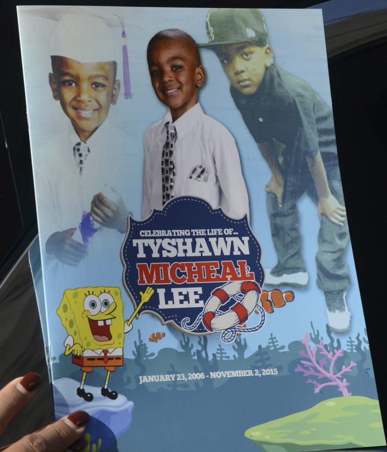 A mourner holds the program for the funeral of 9-year-old Tyshawn Lee on Nov. 10, 2015, at St. Sabina Church in Chicago.