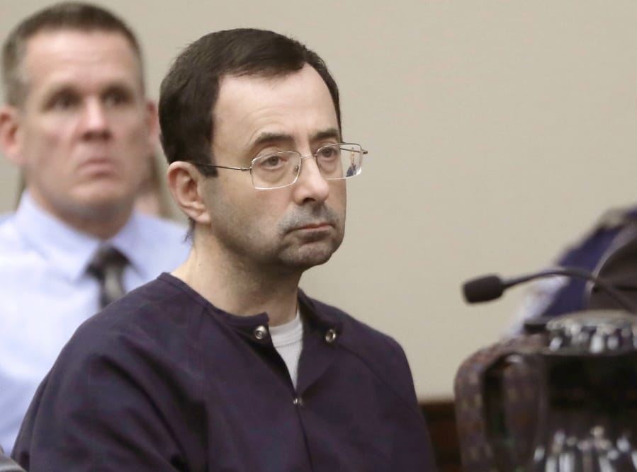 FILE - In this Jan. 24, 2018, file photo, Larry Nassar, a former doctor for USA Gymnastics and member of Michigan State’s sports medicine staff, sits in court during his sentencing hearing in Lansing, Mich. MSU is defending itself against a second wave of lawsuits related to Nassar but says it wants to reach a deal with the additional assault victims. MSU defended itself in a court filing Monday, Aug. 26, 2019.