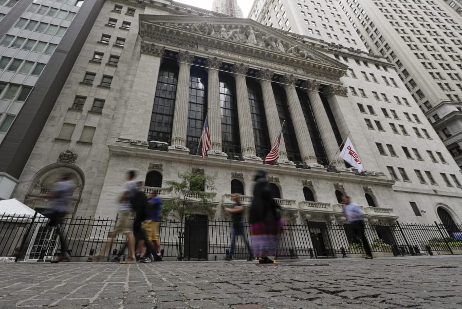 FILE - In this Aug. 23, 2019, file photo pedestrians pass the New York Stock Exchange in New York. Global stock markets were mostly lower Tuesday, Sept. 3, amid revived jitters over U.S.-Chinese trade tension, while wrangling by British lawmakers over whether to try to postpone Brexit saw the pound fall further.