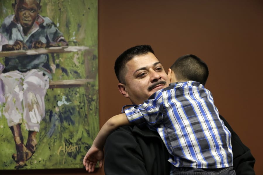 Ignacio Lanuza holds his son, Isaiah, 4, during a portrait session on Oct. 17, 2014, in Seattle. Lanuza, a Mexican immigrant who was nearly deported after a U.S. Immigration and Customs Enforcement lawyer forged a key document in his case, accomplished a fair amount by suing over the misconduct.