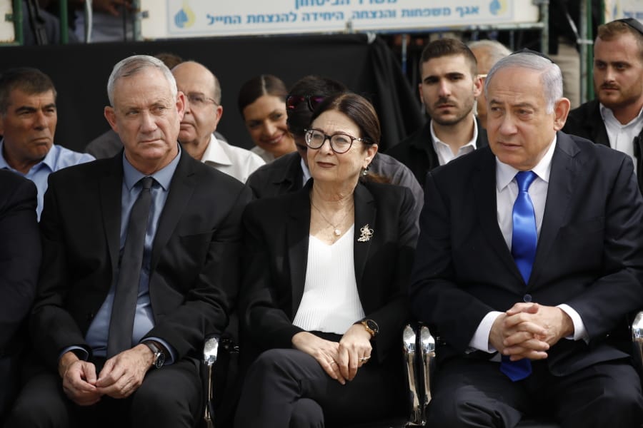 FILE - In this Thursday, Sept. 19, 2019 file photo, Blue and White party leader Benny Gantz, left, Esther Hayut, the Chief Justice of the Supreme Court of Israel, and Prime Minister Benjamin Netanyahu attend a memorial service for former President Shimon Peres in Jerusalem. Israel&#039;s two largest political parties are meeting to discuss the possibility of forming a unity government between them, after last week&#039;s deadlocked national elections.  The Sept.