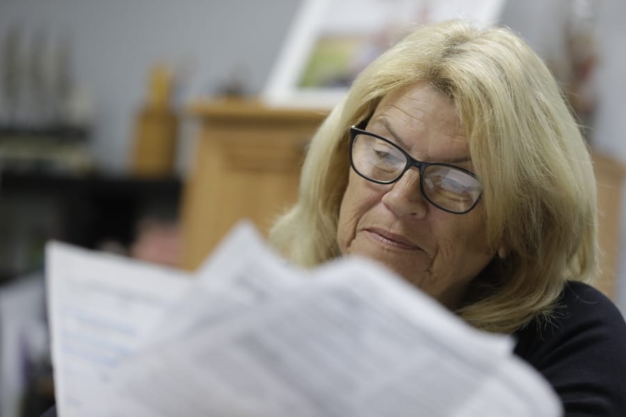 Linda Morris looks over her Medicare statements, Wednesday, Sept. 25, 2019, in Parker City, Ind. Federal law enforcement officials say they&#039;ve taken down a nearly-$2 billion Medicare fraud scheme that exploited curiosity about genetic medicine by having seniors get their cheeks swabbed for unneeded DNA tests.  A Medicare enrollee, Morris said she was roped in at a conference on aging well. The retired high school math and journalism teacher got her cheek swabbed by one of the many health vendors at the event.
