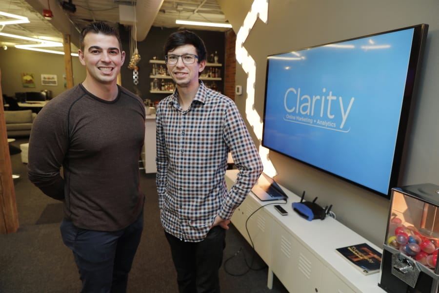 Trenton Erker, left, and Shane Griffiths, co-owners of the digital marketing company Clarity Online, pose Tuesday for a photo in Seattle. Griffiths and Erker use technology for tasks like billing, scheduling appointments, tracking the time they spend on clients’ projects and putting together reports on visits to client websites, as well as using freelancers for other tasks as ways to save money on employment costs, and also have more flexibility when they need specific talents or expertise for a project. (AP Photo/Ted S.