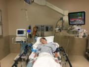 This May 2018, photo provided by Joseph Jenkins shows his son, Jay, in the emergency room of the Lexington Medical Center in Lexington, S.C. Jay Jenkins suffered acute respiratory failure and drifted into a coma, according to his medical records, after he says he vaped a product labeled as a smokable form of the cannabis extract CBD. Lab testing commissioned as part of an Associated Press investigation into CBD vapes showed the cartridge that Jenkins says he puffed contained a synthetic marijuana compound blamed for at least 11 deaths in Europe.
