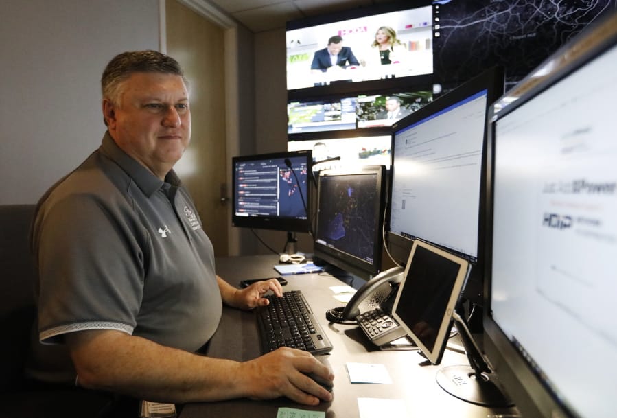 In this July 30, 2019, photo, Paul Hildreth, emergency operations coordinator for the Fulton County School District, works in the emergency operations center at the Fulton County School District Administration Center in Atlanta. Artificial Intelligence is transforming surveillance cameras from passive sentries into active observers that can immediately spot a gunman, alert retailers when someone is shoplifting and help police quickly find suspects. Schools, such as the Fulton County School District, are among the most enthusiastic adopters of the technology.