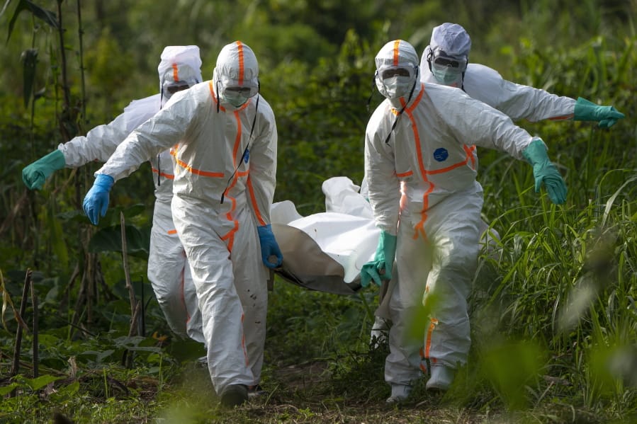FILE - In this Sunday, July 14, 2019 photo, burial workers dressed in protective gear carry the remains someone that died of Ebola, in Beni, Congo. The World Health Organization has issued an unusual statement raising questions about whether Tanzania is covering up possible cases of the deadly Ebola virus. It is a cause for concern during a regional outbreak recently declared a rare global health emergency..