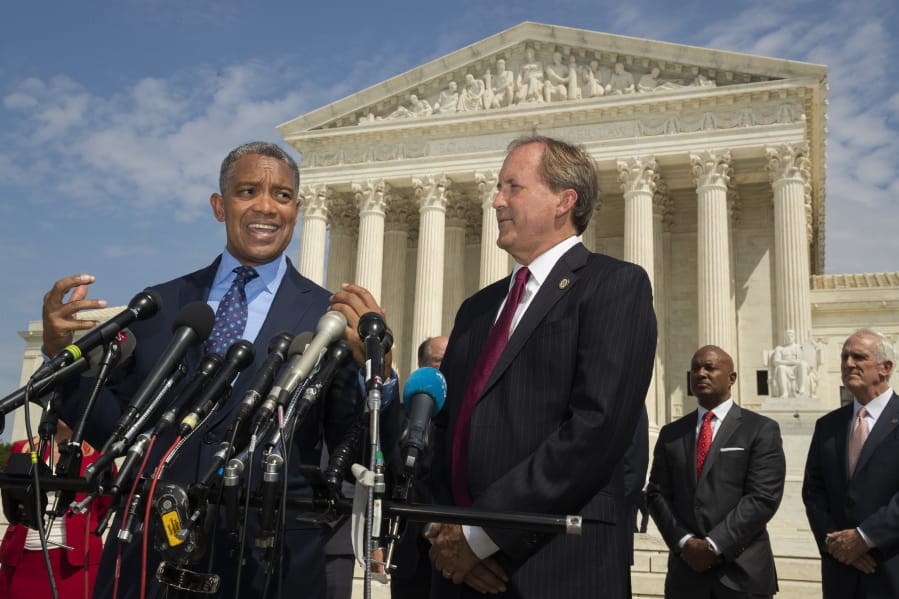 District of Columbia Attorney General Karl Racine, with Texas Attorney General Ken Paxton, right, and a bipartisan group of state attorneys general speaks to reporters in front of the U.S. Supreme Court in Washington, Monday, Sept. 9, 2019 on an antitrust investigation of big tech companies.