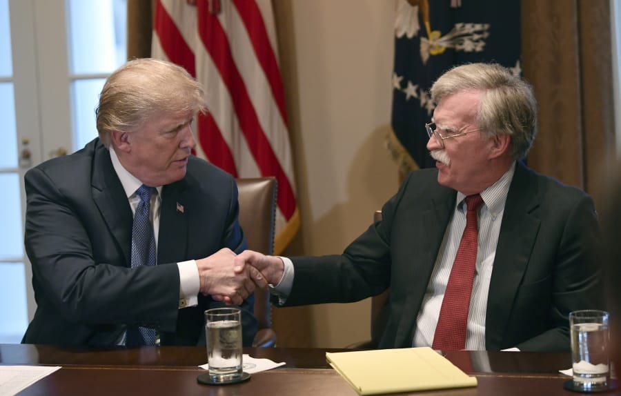 FILE - In this April 9, 2018 file photo, President Donald Trump, left, shakes hands with national security adviser John Bolton in the Cabinet Room of the White House in Washington at the start of a meeting with military leaders. Trump has fired national security adviser John Bolton. Trump tweeted Tuesday that he told Bolton Monday night that his services were no longer needed at the White House.