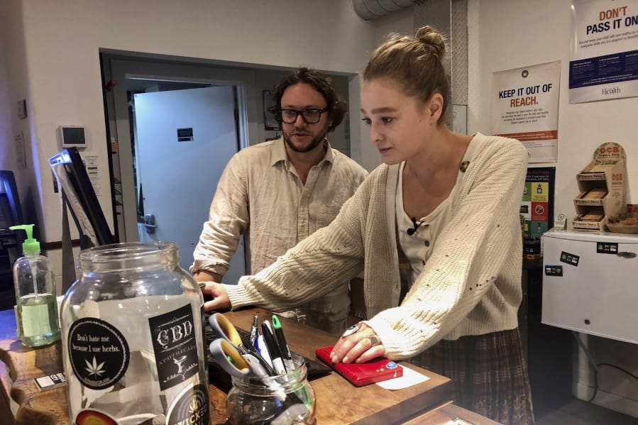 David Alport, owner of the Bridge City Collective marijuana dispensary in Portland, goes over sales numbers Sept. 20 with the store&#039;s general manager Cameron Moore. The company has seen a 31 percent decrease in its sales of vaping products in the past two weeks.