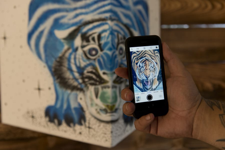 An unreal blue-and-white tiger by Alex Valle turns very orange and black, and very real, when you invert the colors on your smart phone. "We want to invert your perspective. We want to invert the daily lives we all live with art that's fun and surprising," said gallery proprietor Ricky Gaspar.