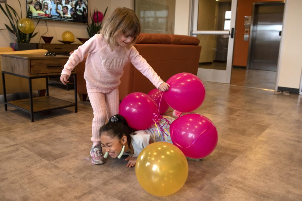 Olivia Mathisen, 4, left, plays with Riley Sombounvong, 7, in the community room at Tearra Flippo&#039;s Vancouver apartment during her cancerversary party in early September. Flippo hosted the party to celebrate the one-year anniversary of the end of active breast cancer treatment. Flippo had chemotherapy, radiation and a double mastectomy, and now takes hormone inhibitors for treatment.