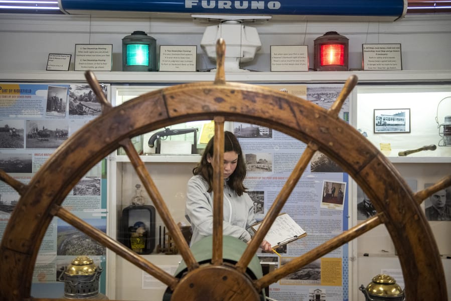 Isabel Alanis, 12, takes notes on the historic steering wheel from a Columbia River ferry during an Odyssey Middle School class visit to the Clark County Historical Museum's new "Currents of Progress" exhibit.