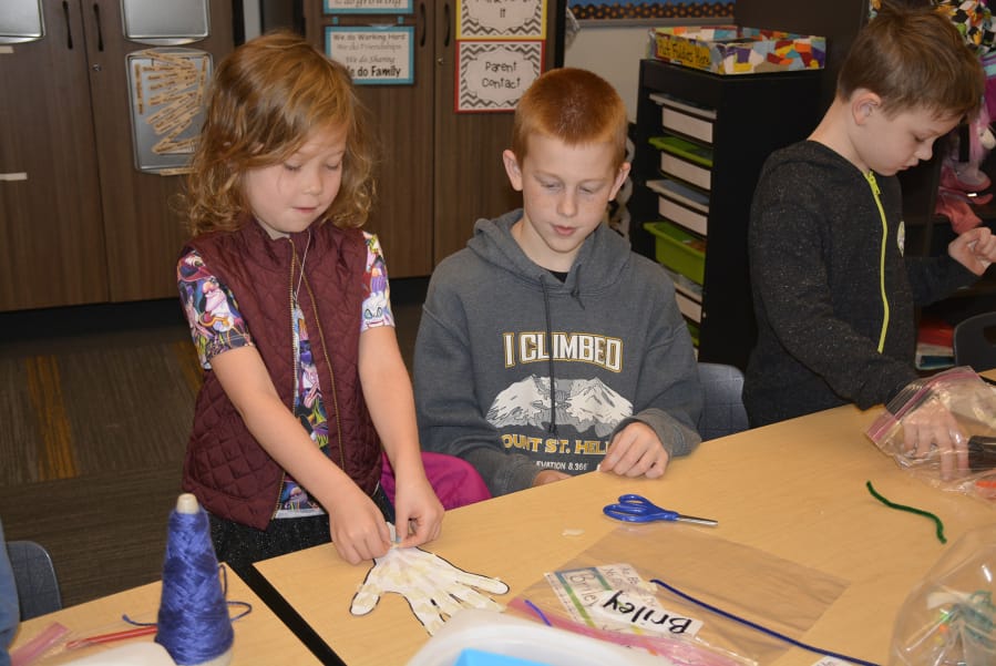 Briley Johnson and Jacob Sanders work together to construct a moving hand.