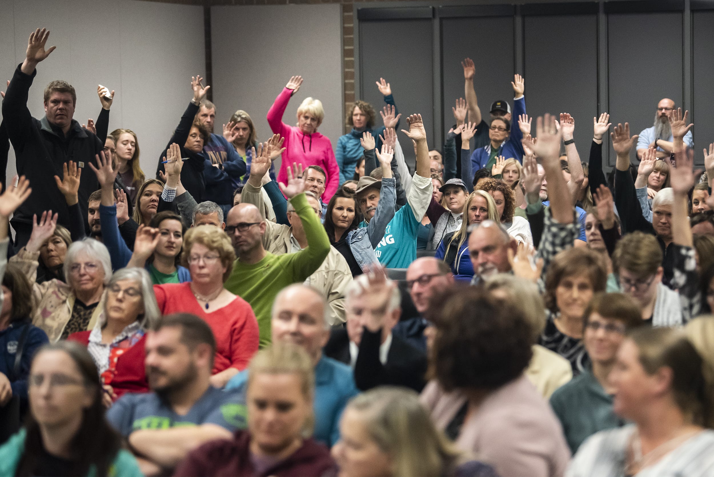 Attendees raise their hands to show their opposition to new sex education curriculum during a Battle Ground Public Schools Board of Directors meeting on Monday night, Oct. 14, 2019.
