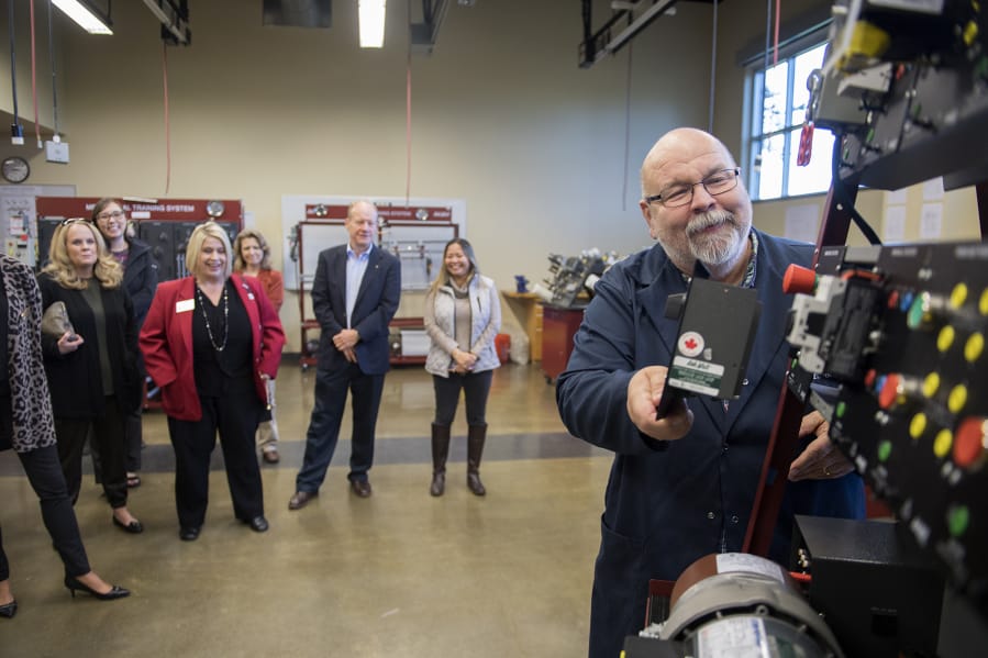 Mechatronics instructor Larry Smith greets guests during a tour at Clark College's Columbia Tech Center campus Monday. The tour was part of the 10th anniversary celebration of the facility.