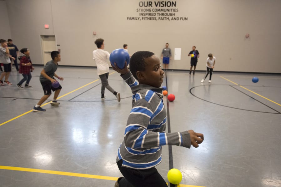 LEADOPTION Jayden Mwaura, 12, takes aim while playing dodgeball with friends during a new after school after-school program for middle school students at the Clark County Family YMCA on Wednesday afternoon. Evergreen Public Schools formally started the new program this year to make sure middle school students have somewhere to go on days they leave school early so staff can meet and train.