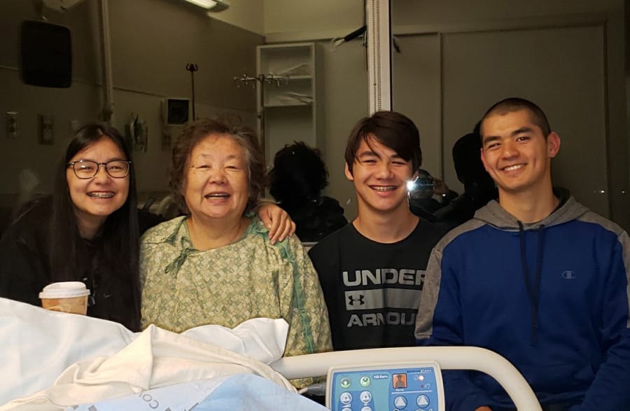 Jung VanAtta visits with her grandchildren, from left, Alexis, Elijah and Trenton Oh, on Wednesday at the hospital after she spent three days lost in the woods in Skamania County.
