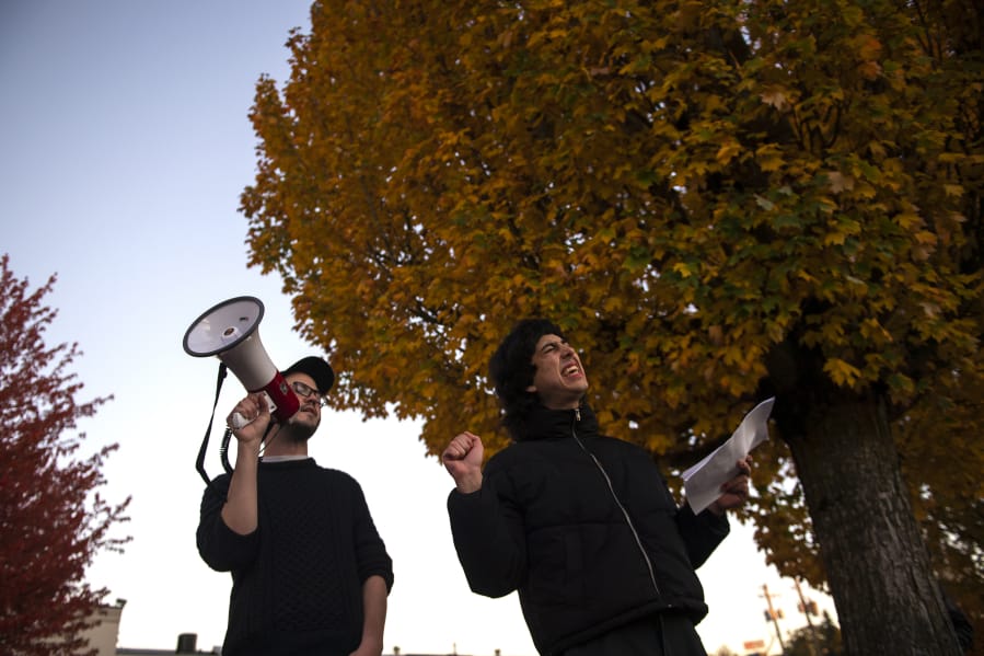 Emmett Schlenz, left, and Abby, who declined to giver her last name, sing pro-union songs at a rally outside the Burgerville corporate offices in Vancouver on Thursday night. The union represents workers at five Portland Burgerville locations, and has been engaged in a strike since Wednesday.