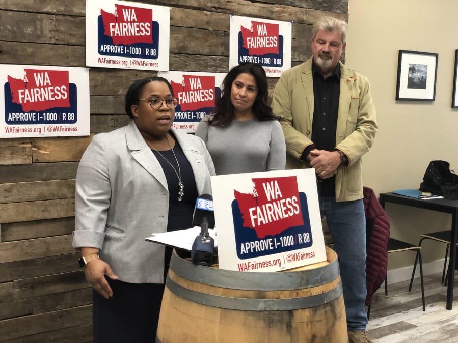 Cherika Carter, WA Fairness campaign manager, speaks during Tuesday's news conference supporting Referendum 88 as state Rep. Monica Stonier, D-Vancouver, and Steven Johnson, a member of VoteVets.org, listen.